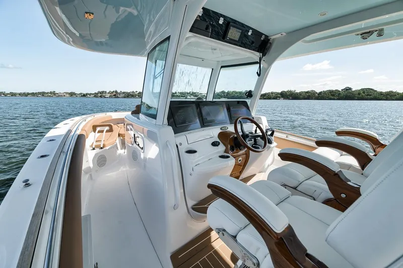 Slide: The Image of 2022 HCB Lujo boat interior with luxurious seating and advanced navigation system on a serene lake. - 39