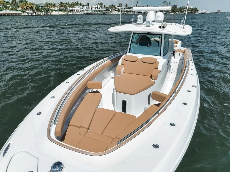 Slide: The Image of 2022 HCB Lujo boat with tan seating, cruising on calm waters. - 45