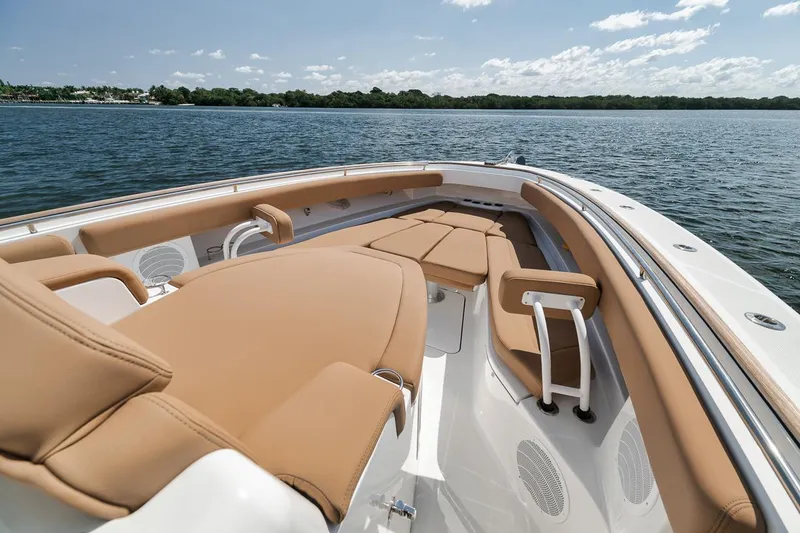 Slide: The Image of 2022 HCB Lujo boat with luxurious tan seating on a calm lake. - 46