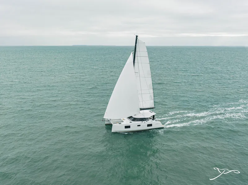 Slide: The Image of Sailing catamaran Nautitech 40 Open 2025 gliding on open sea under cloudy skies. - 0