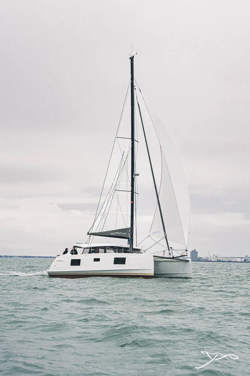Slide: The Image of 2025 Nautitech 40 Open catamaran sailing on calm waters under a cloudy sky. - 4