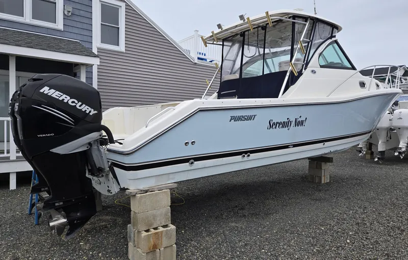 Slide: The Image of 2006 Pursuit 3370 Offshore boat with Mercury engine on blocks, near coastal house. - 0