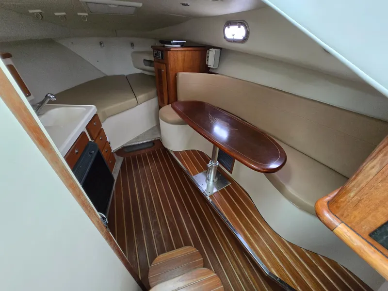 Slide: The Image of 2006 Pursuit 3370 Offshore cabin with wood flooring, kitchenette, and seating area. - 1