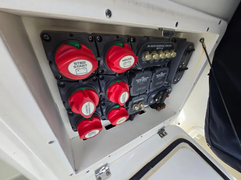 Slide: The Image of Electrical panel of a 2006 Pursuit 3370 Offshore boat with red switches and fuses. - 21