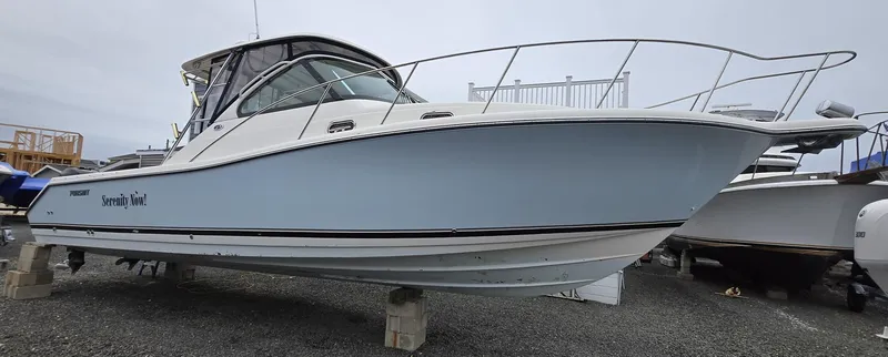 Slide: The Image of 2006 Pursuit 3370 Offshore boat on display, elevated on blocks. - 3