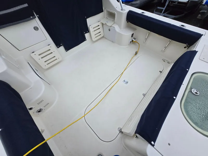 Slide: The Image of 2006 Pursuit 3370 Offshore boat interior with seating and yellow power cable. - 6