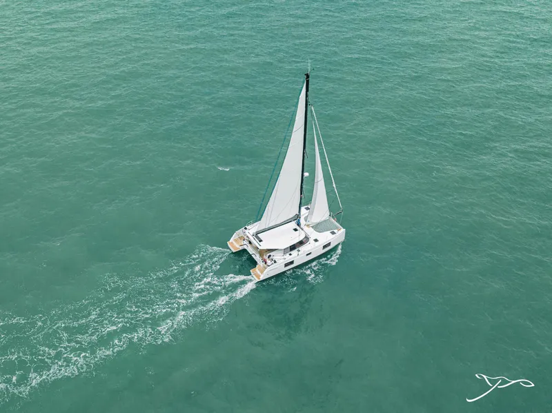Slide: The Image of Aerial view of 2025 Nautitech 40 Open catamaran sailing on turquoise waters. - 8