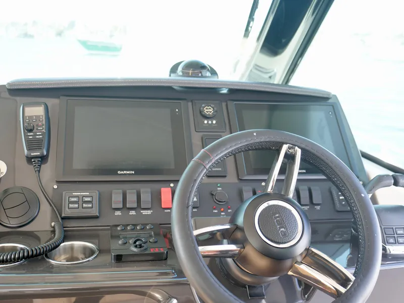 Slide: The Image of Control panel of a 2016 Tiara Yachts Q44, featuring steering wheel and navigation screens. - 13