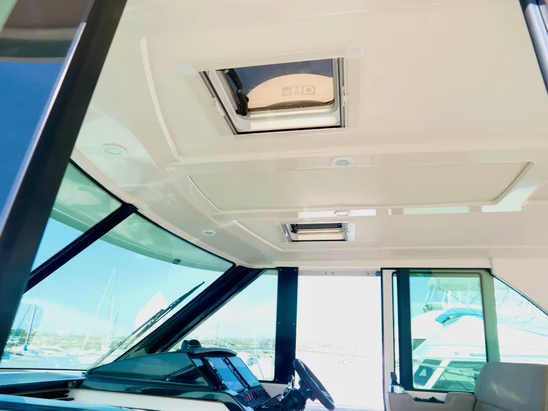 Slide: The Image of 2016 Tiara Yachts Q44 interior helm with sunroof and modern dashboard. - 16