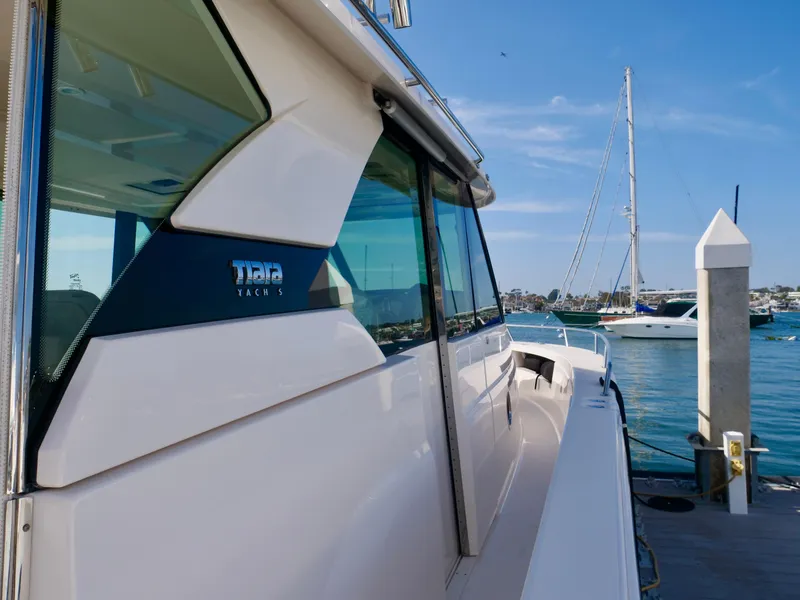 Slide: The Image of 2016 Tiara Yachts Q44 docked, showcasing sleek design and waterfront view. - 22