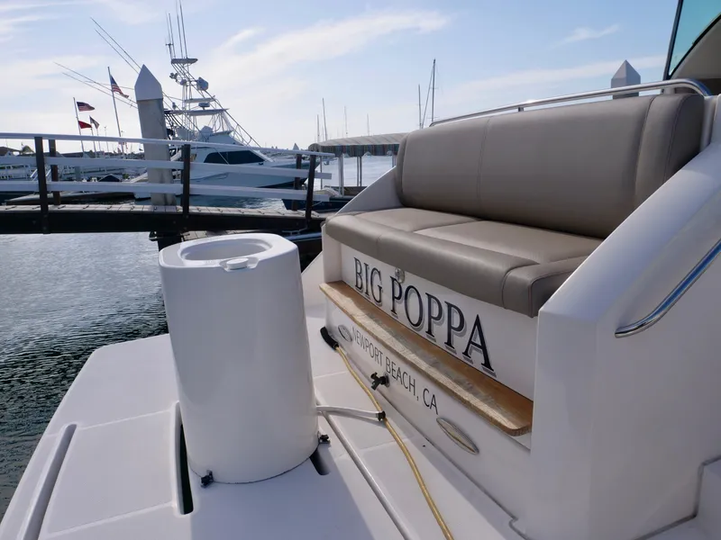 Slide: The Image of 2016 Tiara Yachts Q44 at dock, featuring "Big Poppa" nameplate and seating area. - 26