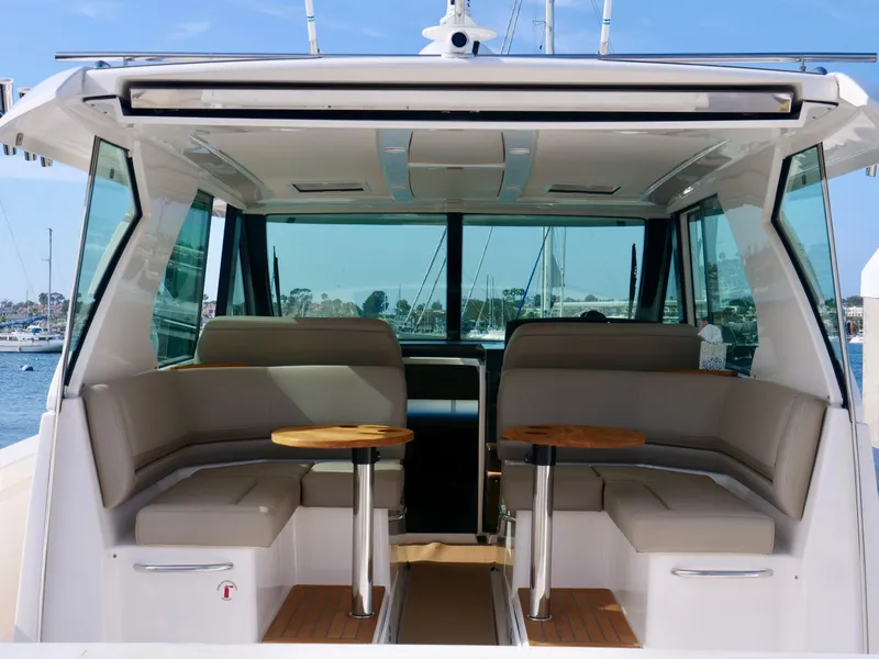 Slide: The Image of 2016 Tiara Yachts Q44 interior with seating and tables, docked at marina. - 27