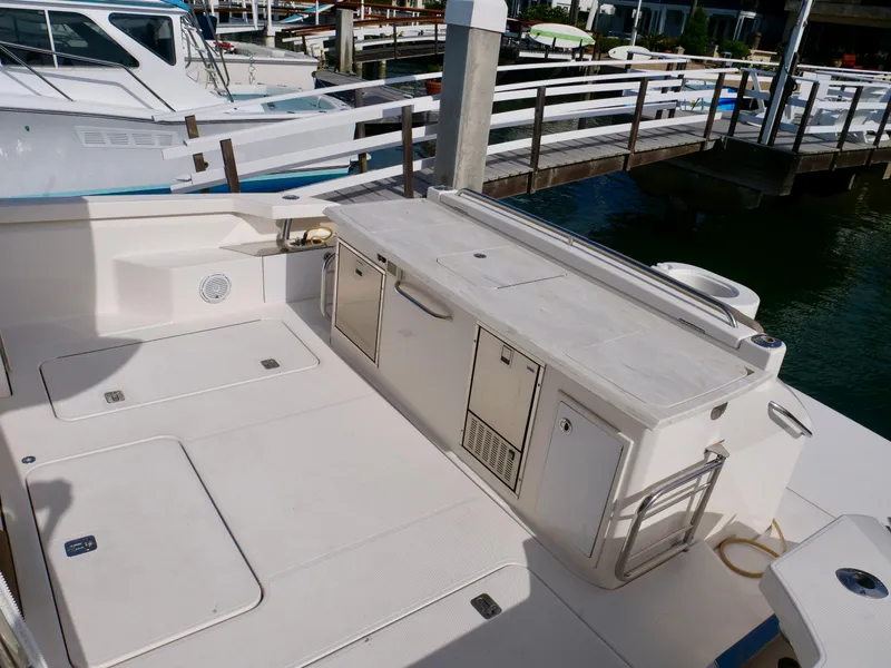 Slide: The Image of 2016 Tiara Yachts Q44 deck with storage compartments and dock view. - 29