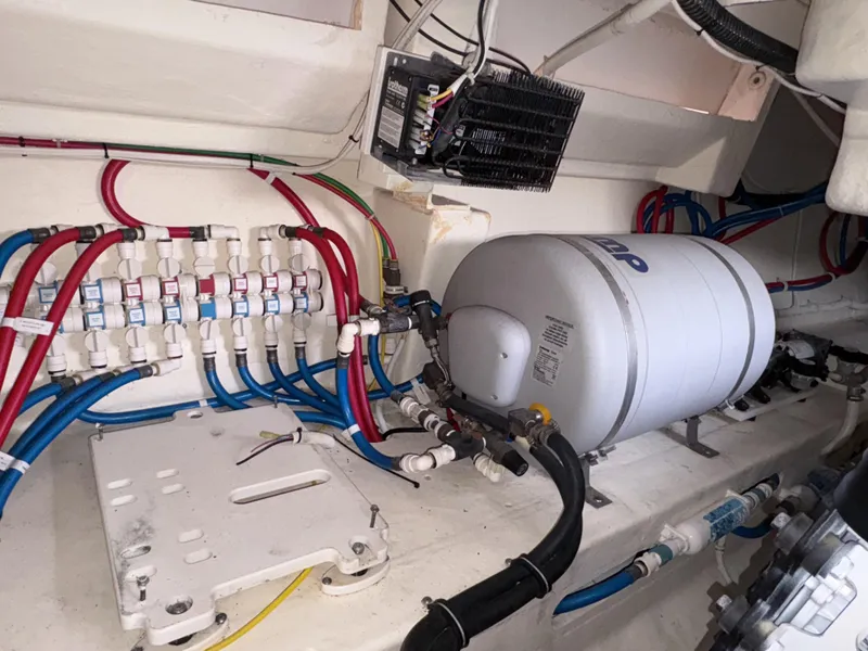 Slide: The Image of Engine room of 2016 Tiara Yachts Q44, featuring plumbing and electrical systems. - 34