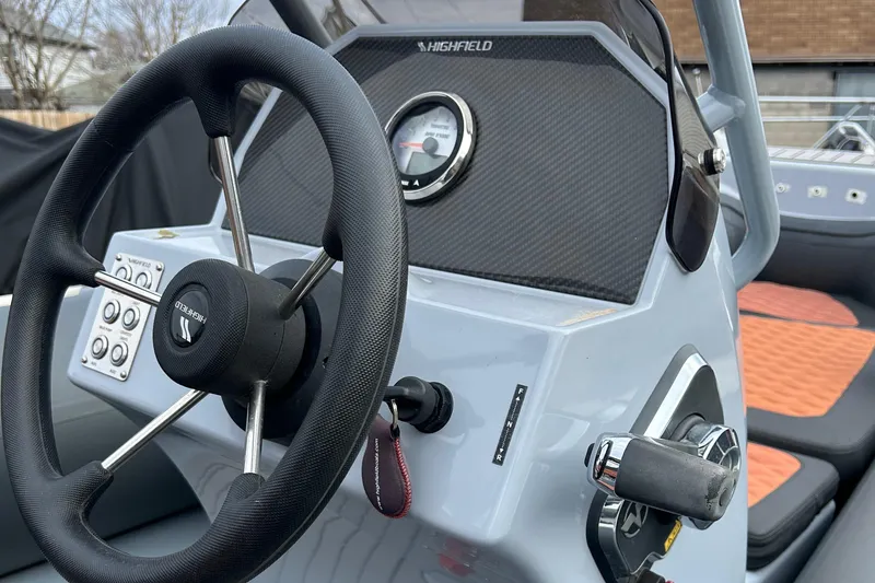 Slide: The Image of 2021 Highfield Sport 460 boat dashboard with steering wheel and control panel. - 13