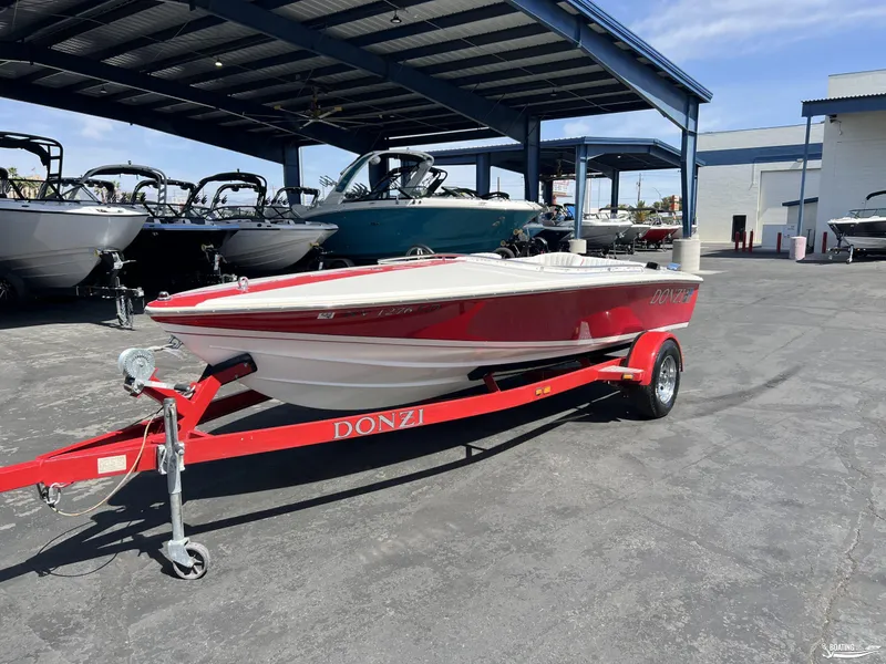 Slide: The Image of 1996 Donzi Sweet 16 boat on a red trailer in a marina setting. - 1
