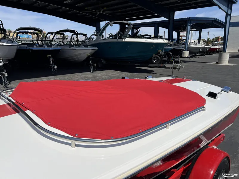 Slide: The Image of 1996 Donzi Sweet 16 boat with red cover, parked in a marina with other boats. - 10