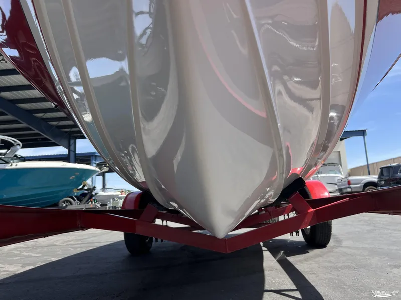 Slide: The Image of 1996 Donzi Sweet 16 boat hull on red trailer, parked outdoors. - 18