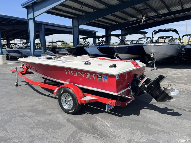 Slide: The Image of 1996 Donzi Sweet 16 boat in red, parked on a trailer under a metal canopy. - 2