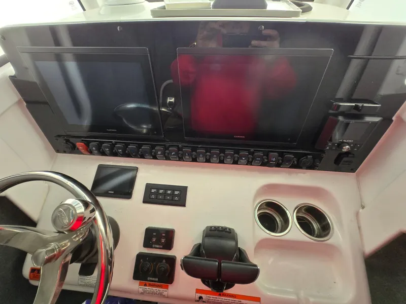 Slide: The Image of 2023 Sea Hunt Ultra 265 SE boat dashboard with dual screens and controls. - 10