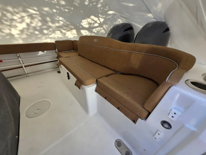 Slide: The Image of 2023 Sea Hunt Ultra 265 SE boat interior with brown cushioned seating. - 12