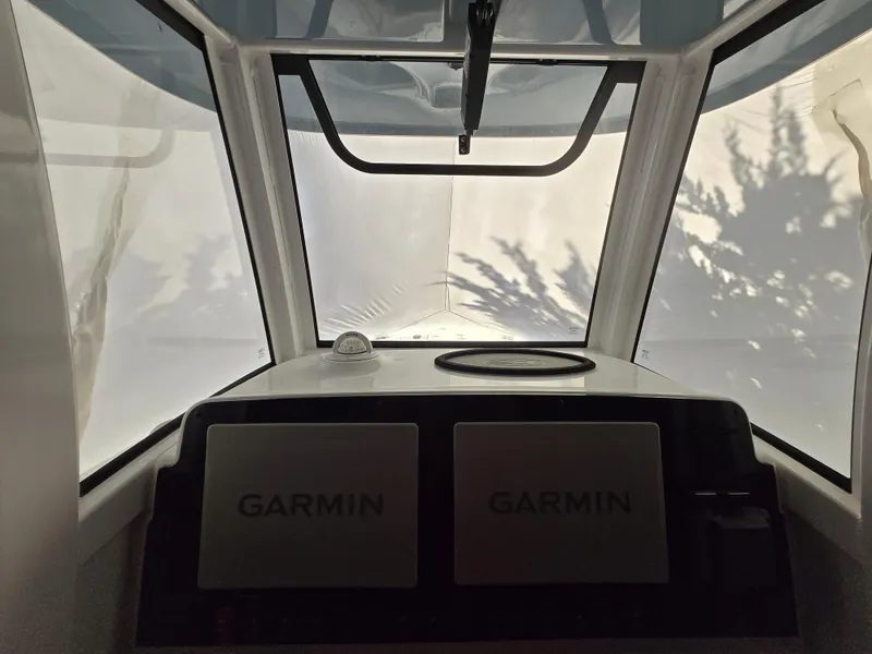 Slide: The Image of 2023 Sea Hunt Ultra 265 SE dashboard with Garmin displays, viewed from inside the boat. - 13