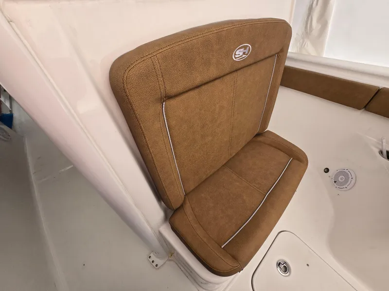 Slide: The Image of 2023 Sea Hunt Ultra 265 SE boat seat with brown upholstery and logo. - 16