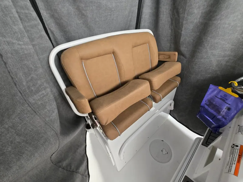 Slide: The Image of 2023 Sea Hunt Ultra 265 SE boat seat with tan upholstery and armrests. - 17