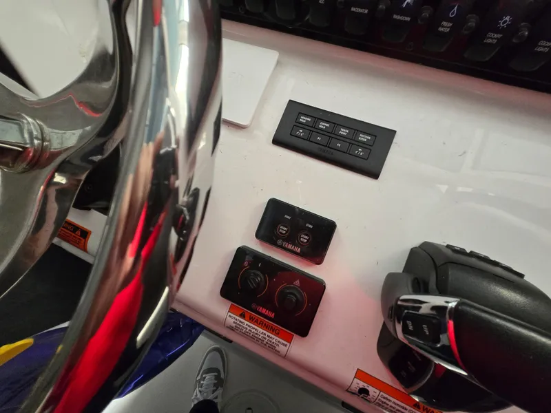 Slide: The Image of Control panel of 2023 Sea Hunt Ultra 265 SE boat with steering wheel and switches. - 19