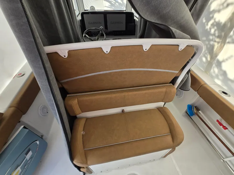 Slide: The Image of 2023 Sea Hunt Ultra 265 SE boat interior with tan seating and Garmin displays. - 21