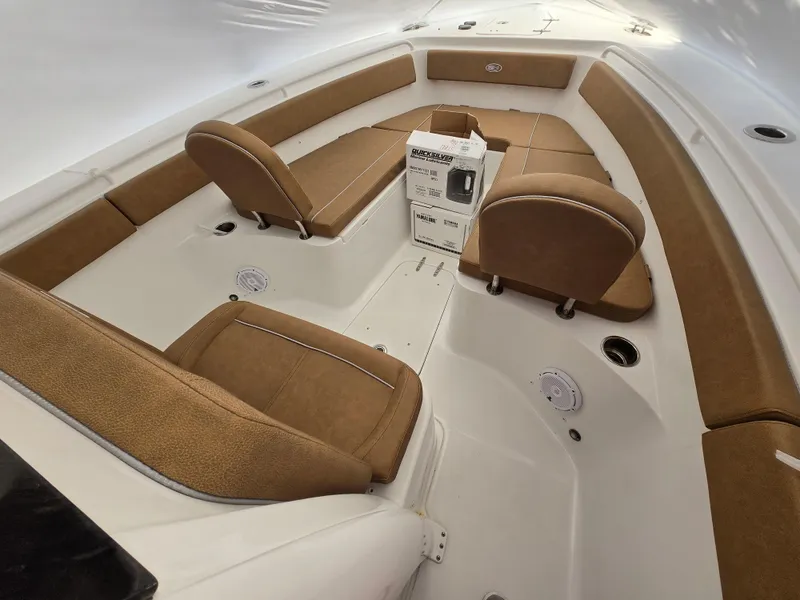 Slide: The Image of 2023 Sea Hunt Ultra 265 SE boat interior with tan seating and a central console. - 23