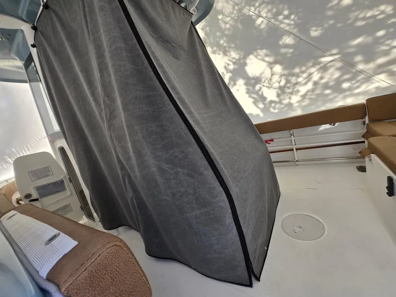 Slide: The Image of 2023 Sea Hunt Ultra 265 SE interior with seating and privacy curtain. - 27