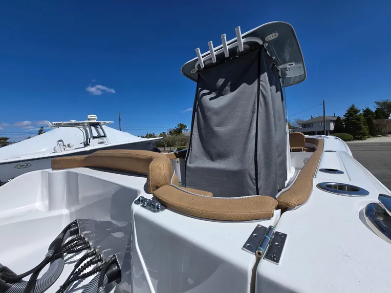 Slide: The Image of 2023 Sea Hunt Ultra 265 SE boat interior with seating and console, under clear blue sky. - 29
