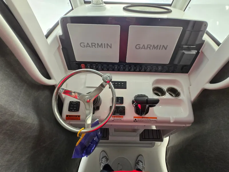 Slide: The Image of 2023 Sea Hunt Ultra 265 SE helm with Garmin displays and steering wheel. - 6