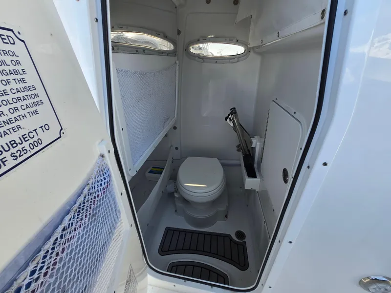 Slide: The Image of 2023 Sea Hunt Ultra 265 SE boat interior with compact marine toilet and storage. - 8