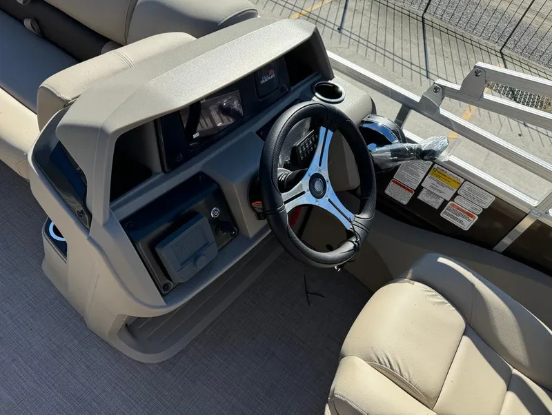 Slide: The Image of 2025 Sun Tracker 24 Sportfish XP3 boat interior with beige seating and cup holders. - 16