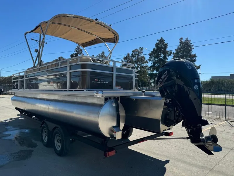 Slide: The Image of 2025 Sun Tracker 24 Sportfish XP3 pontoon boat on trailer, parked outdoors. - 8