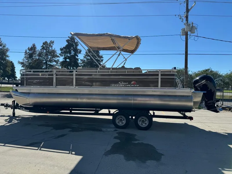 Slide: The Image of 2025 Sun Tracker 24 Sportfish XP3 boat interior with beige seating and console. - 9