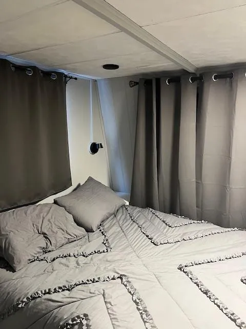 Slide: The Image of Cozy bedroom in 1976 Sumerset houseboat with gray bedding and curtains. - 10