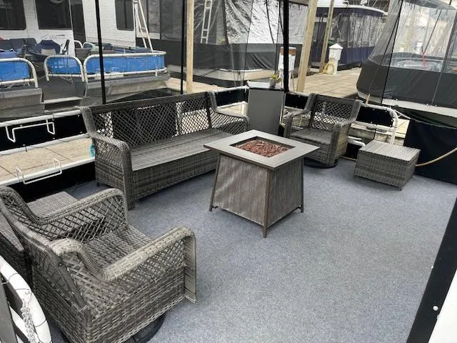 Slide: The Image of Outdoor seating area on a 1976 Sumerset houseboat with wicker furniture and fire pit. - 2