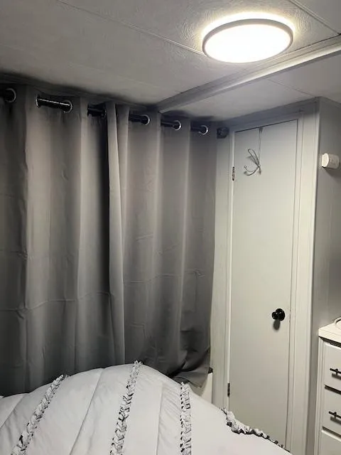 Slide: The Image of Interior of 1976 Sumerset houseboat bedroom with gray curtains and modern lighting. - 4