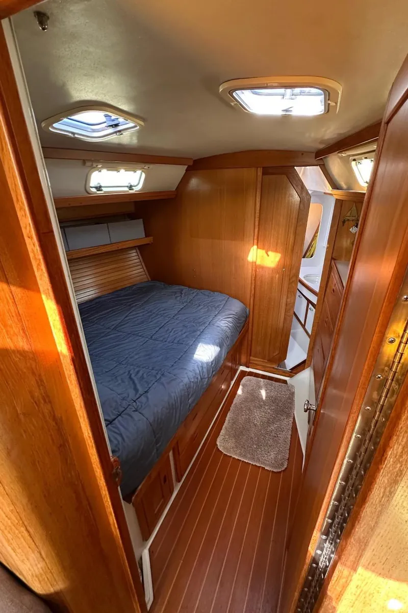Slide: The Image of Cozy cabin interior of a 1993 Catalina 42 sailboat with wooden finishes and a comfortable bed. - 12