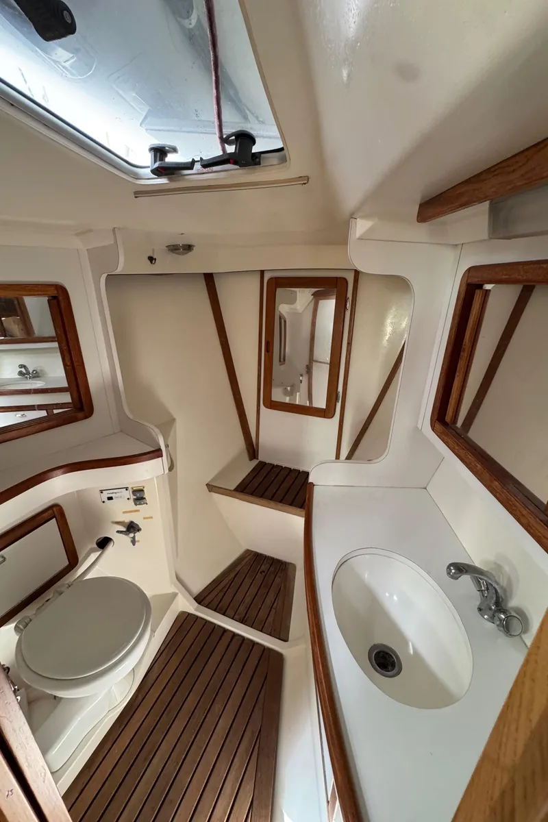 Slide: The Image of Interior of 1993 Catalina 42 sailboat bathroom with wooden accents and white fixtures. - 18