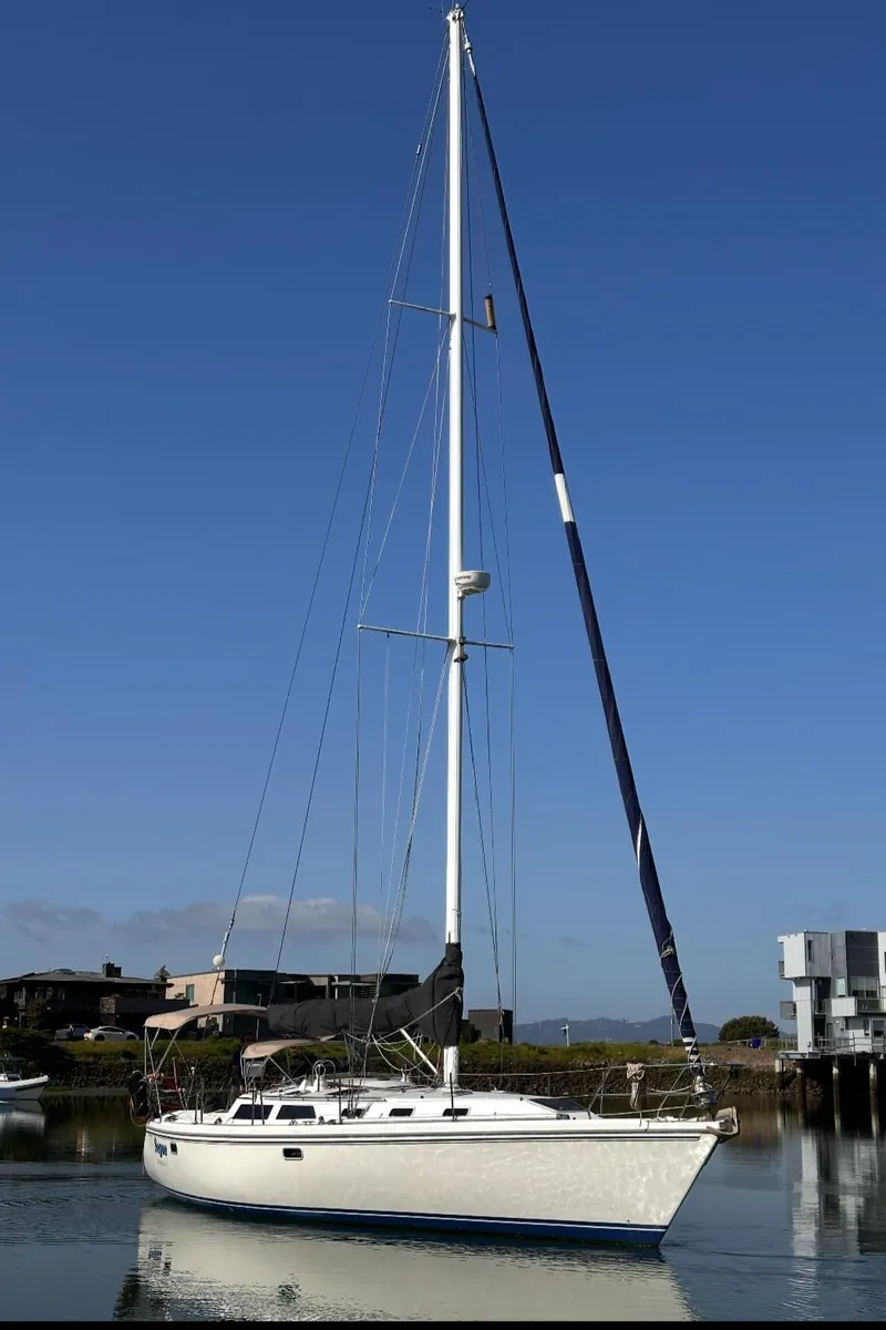 Slide: The Image of Sailboat Catalina 42, 1993 model, docked in a serene marina under clear blue skies. - 28
