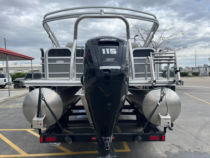 Slide: The Image of 2022 Trifecta 22 LE Rear Fish pontoon boat with Mercury 115 engine, parked outdoors. - 5