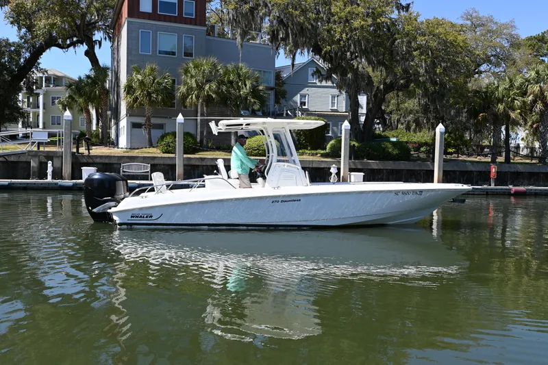 The Image of 2014 Boston Whaler 270 Dauntless boat docked in a scenic marina setting. - 0