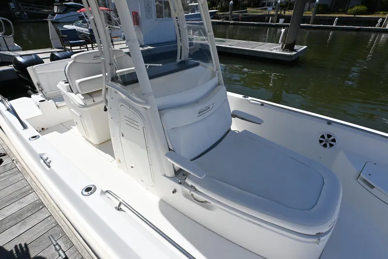 Slide: The Image of 2014 Boston Whaler 270 Dauntless boat docked, featuring spacious seating and sleek design. - 15