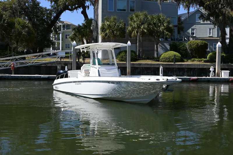 Slide: The Image of 2014 Boston Whaler 270 Dauntless boat docked in a serene waterfront setting. - 2