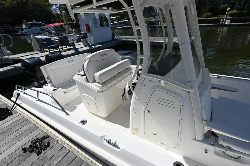 Slide: The Image of 2014 Boston Whaler 270 Dauntless boat docked, featuring seating and console. - 21