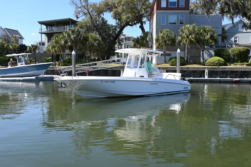 Slide: The Image of 2014 Boston Whaler 270 Dauntless boat docked in a serene waterfront setting. - 3